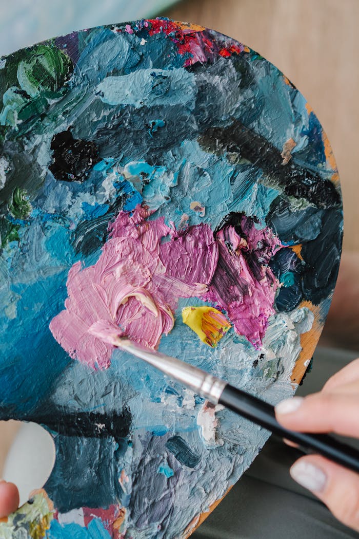Artist using a paintbrush and colourful paint palette